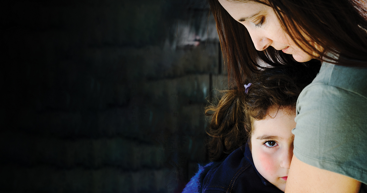 Mother hugging scared child
