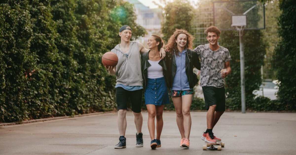 Group of teenagers hanging out on a basketball court