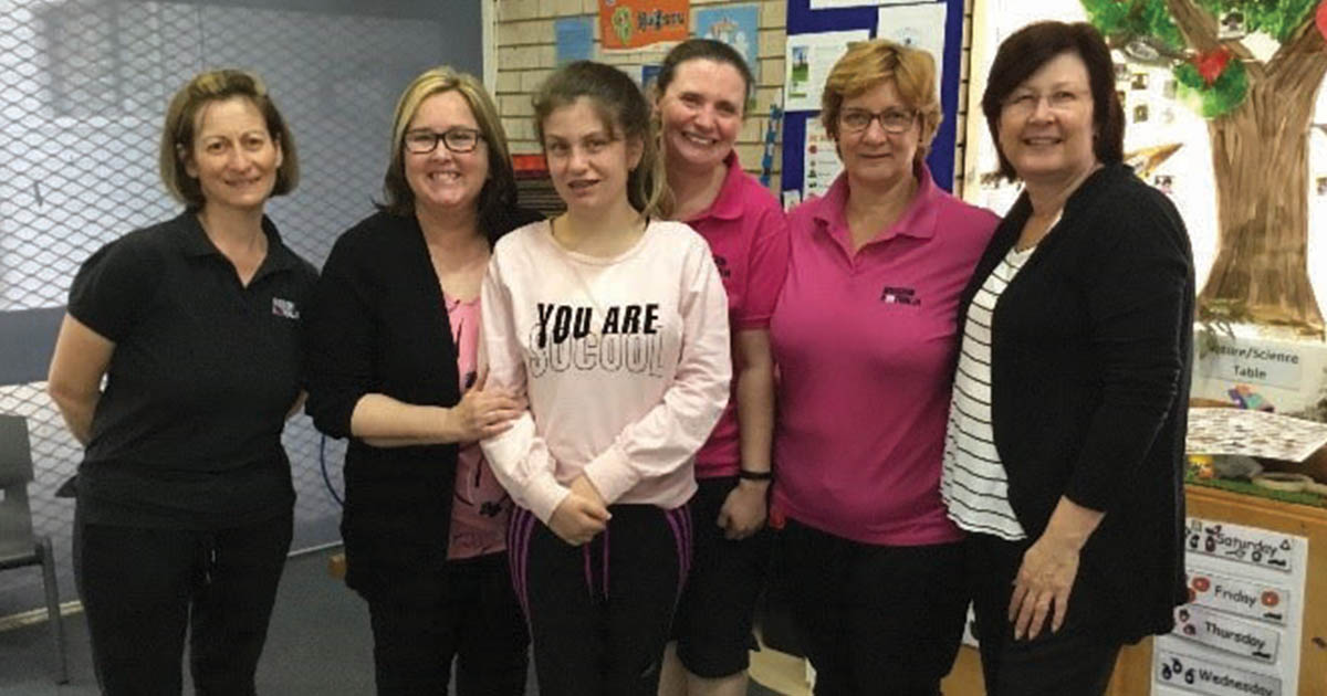 Happy girl surrounded by Mission Australia staff