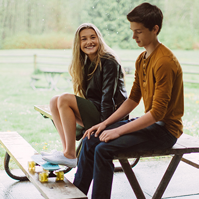 Young girl and boy sitting on a park table