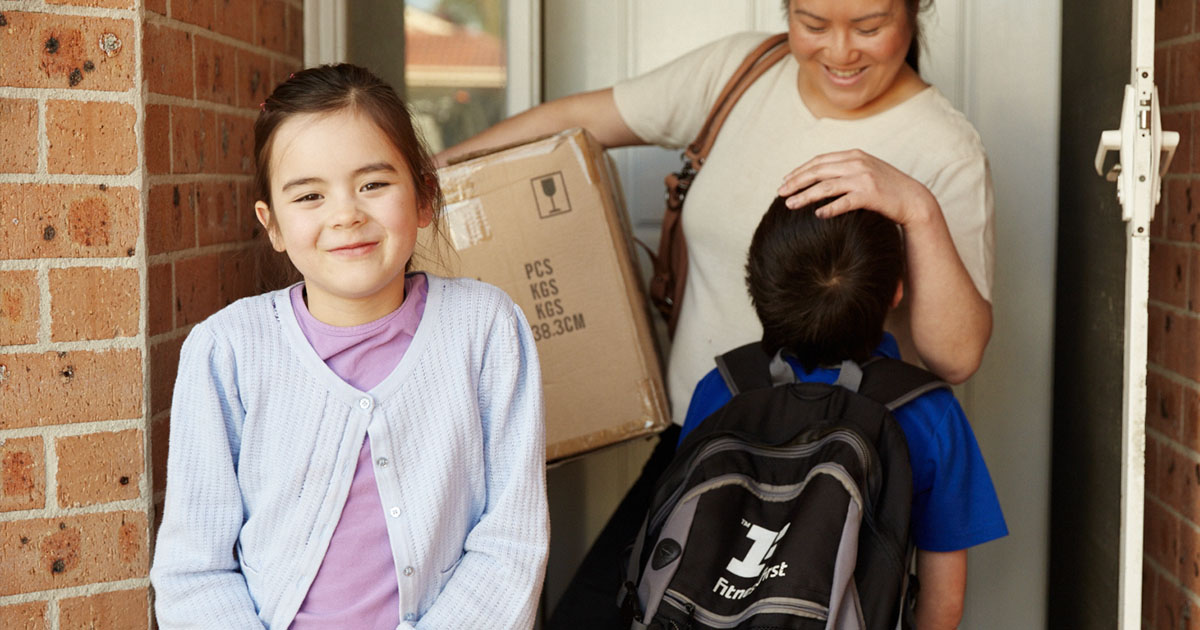 Girl and her family in front of housing