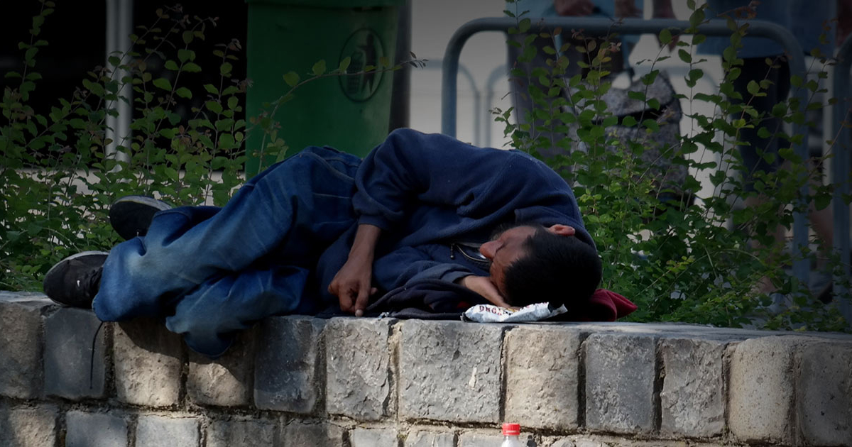 Homeless man lying on a bench