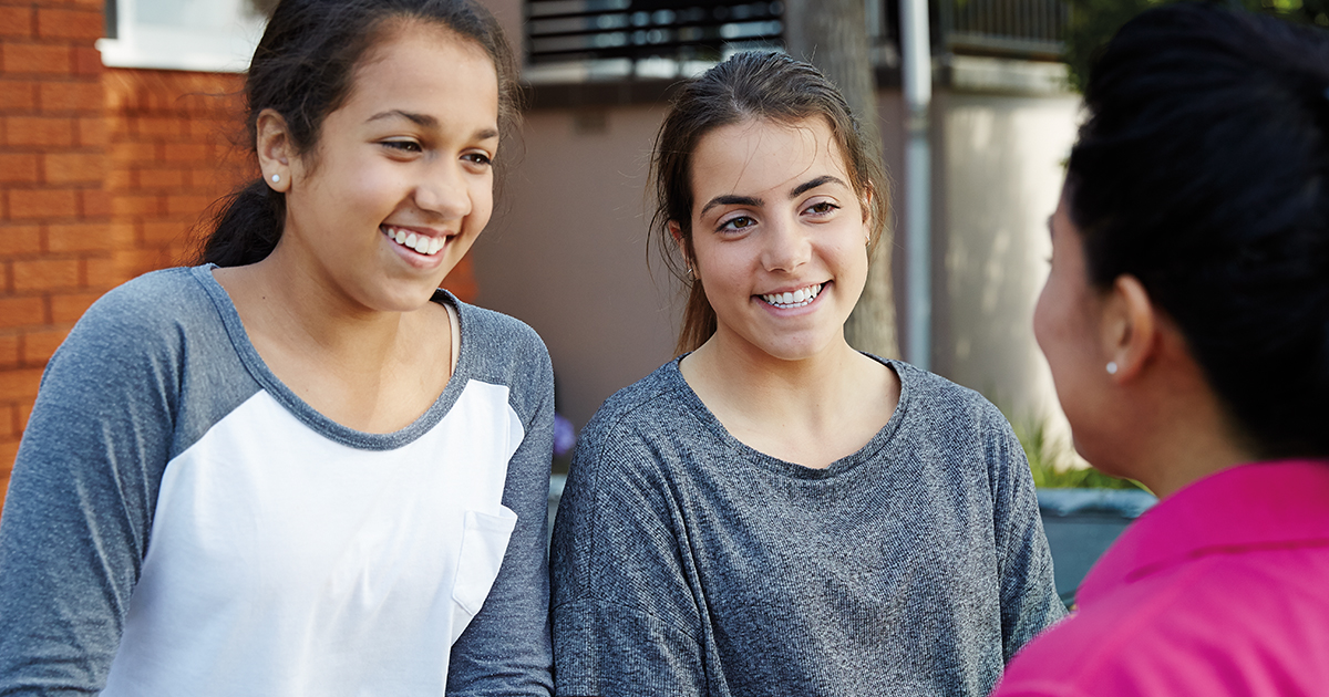 Happy teen girls with case worker