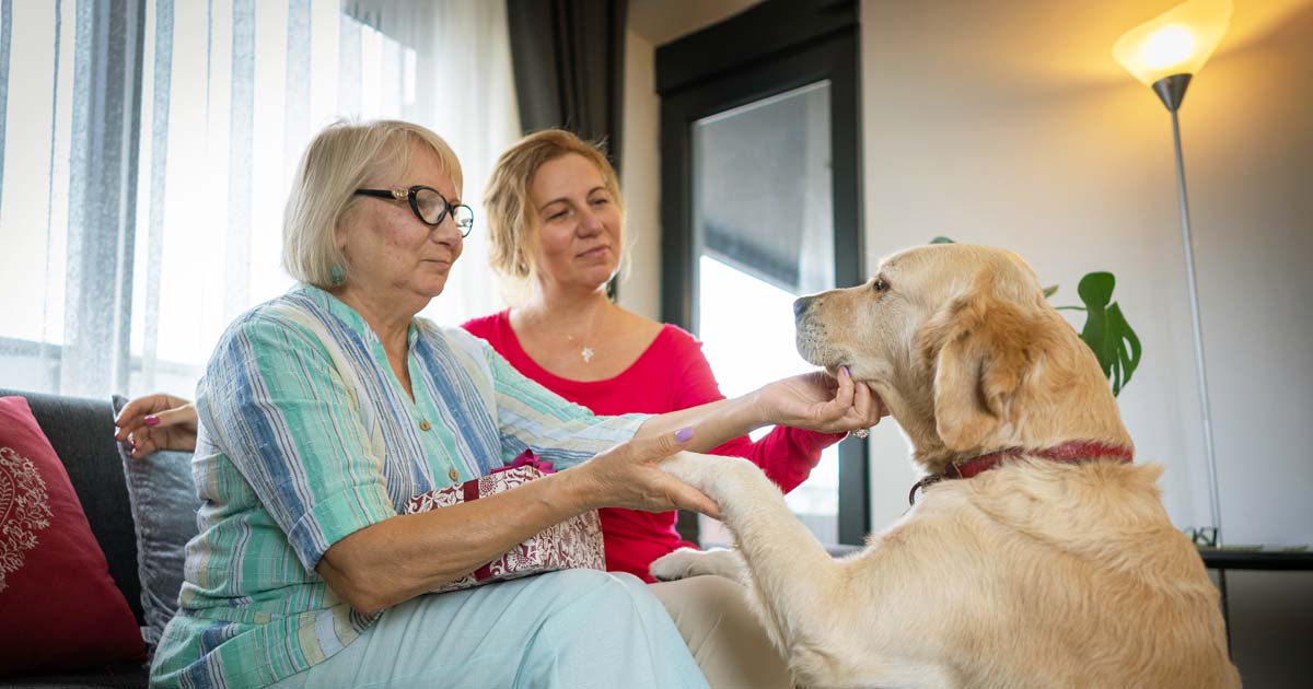 Janelle and her mum patting their dog