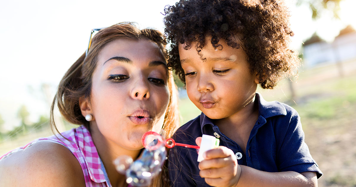 Parent and kid blowing bubbles