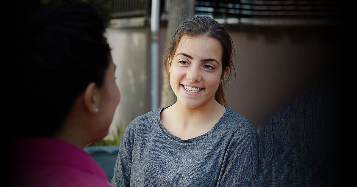 A young girl smiling outside