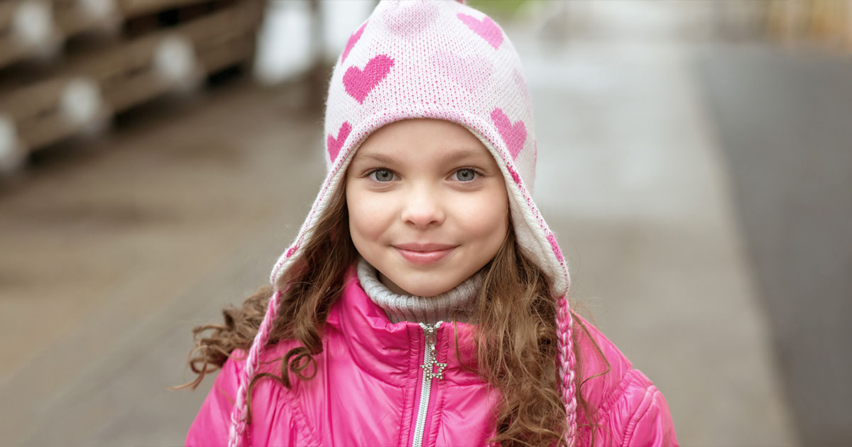 A child wearing a beanie looking smiling
