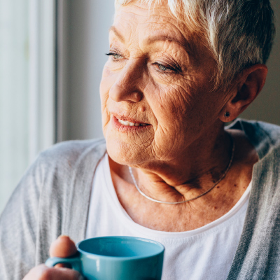 Elderly woman holding coffee cup