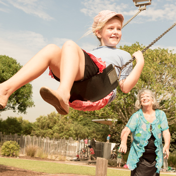 Grandmother pushing her grandaughter on a swing