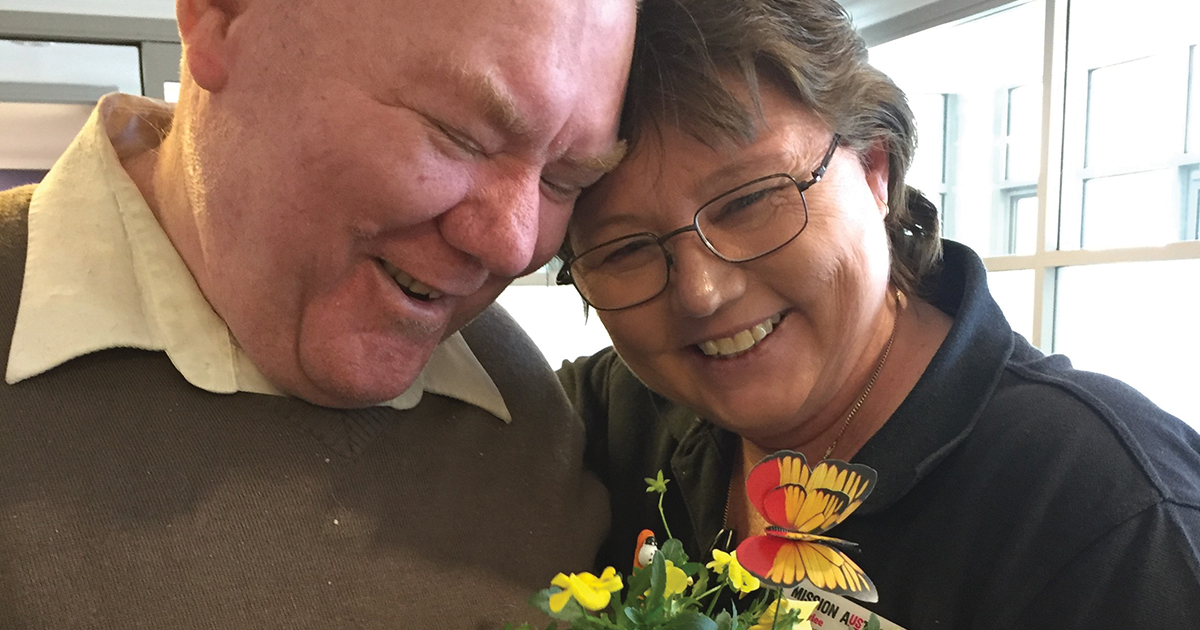 Happy man with flowers and case worker